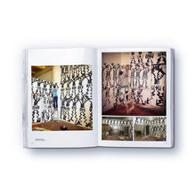 Load image into Gallery viewer, A colorful, abstract artwork on a wall featured on a page of a paperback book titled 'The elephant never forgets' by Danny Minnick.