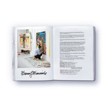 Load image into Gallery viewer, A colorful, abstract artwork in a studio featured on a page of a paperback book titled 'The elephant never forgets' by Danny Minnick.